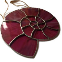 Ammonite stained glass light catcher in streaky pink glass